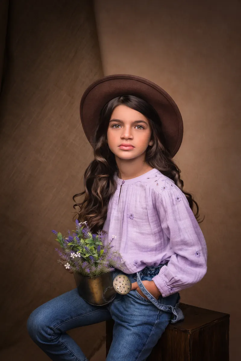 Niña con sombrero y blusa lila
