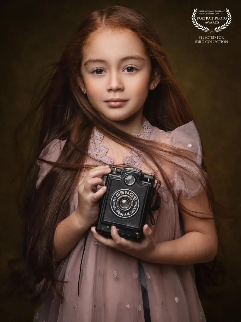 Niña con cámara antigua
