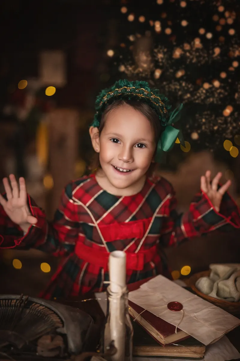 Niña con vestido de cuadros escoceses y cintillo verde